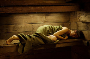 Woman Wrapped in Blanket Lying in Shed